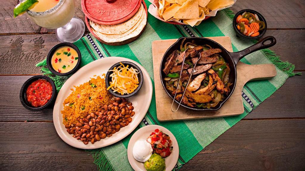 Slow Marinated Fajitas · Our slow marinated fajita meat is served in a warm skillet with caramelized onions and bell peppers, with a side of our house blend of cheeses, sour cream and a side of our always-fresh guacamole, house-made pico de gallo and fresh handmade flour tortillas.