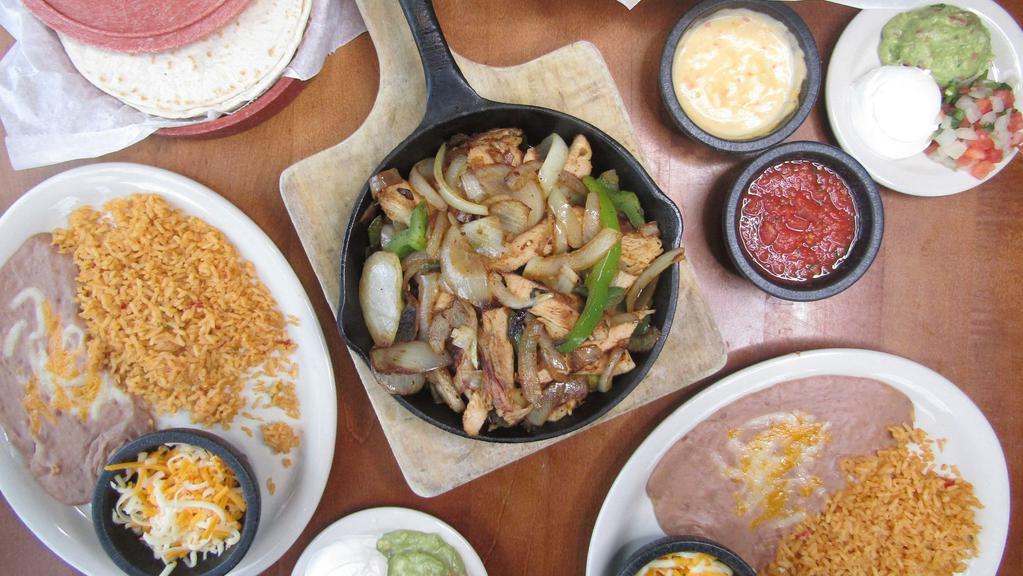 Double Order Of  Fajitas · Our slow marinated fajita meat is served in a warm skillet with caramelized onions and bell peppers, with a side of our house blend of cheeses, sour cream and a side of our always-fresh guacamole, house-made pico de gallo and fresh handmade flour tortillas. Choose four sides.
