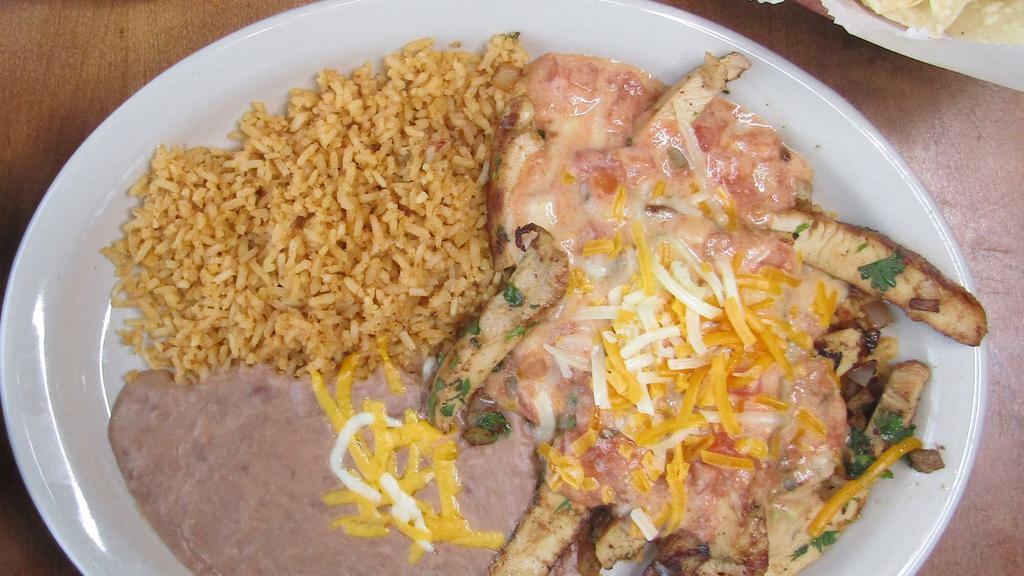 Pollo Ranchero · A slow marinated chicken breast sliced and sauteed with diced onions and fresh cilantro. Smothered with melted cheddar and jack cheeses and our home-made ranchero cheese sauce. Served on a bed of rice.