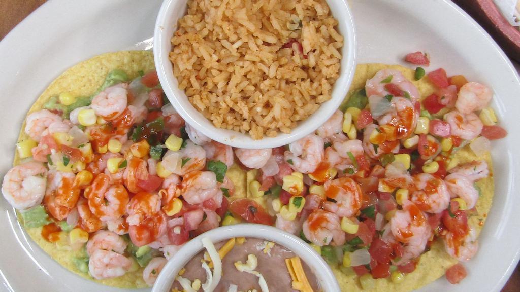 Shrimp Ceviche Tostadas · Fresh cooked shrimp diced and mixed with our house-made pico de gallo and sweet kernel corn, served atop two tostadas each with a guacamole spread then finished with a fresh squeeze of lime juice and a tangy cholula drizzle.
