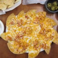 Classic Chicken Nachos · Our Classic Chicken nachos with cheese and guacamole and sour cream on the side
