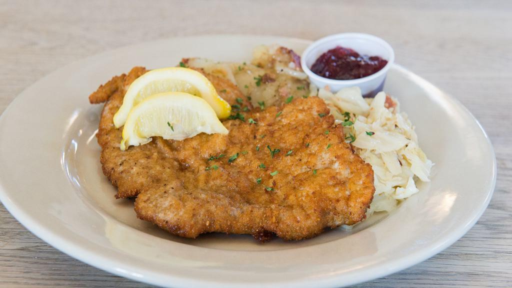 Schnitzel Wiener Art · Classic breaded pork cutlet fried crisp and golden brown. Served with German potato salad, fried cabbage, and cranberry sauce.