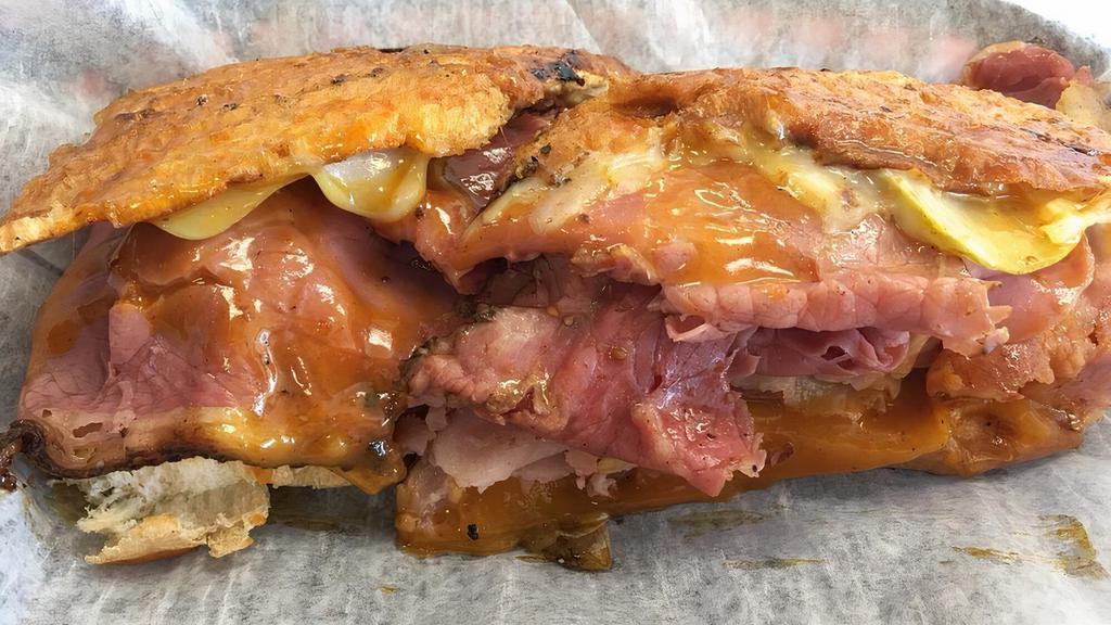 Havana · Grilled pastrami, smoked ham, Swiss, cheddar, pickles, secret sauce, on flattened bread.