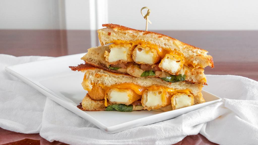 Over The Top Grilled Cheese · This one is for all the cheese lovers! Parmesan-crusted sourdough loaded with provolone and cheddar cheese, topped with four crispy mozzarella sticks, fresh tomato, fresh basil and a dash of balsamic vinegar; served with choice of side.