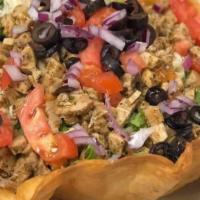 Taco Salad · Taco meat served in a taco shell on a bed of lettuce, tomatoes, cheese, black olives, sour c...