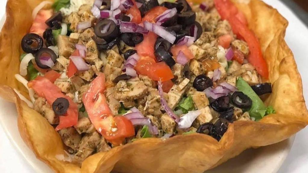 Taco Salad · Taco meat served in a taco shell on a bed of lettuce, tomatoes, cheese, black olives, sour cream, and salsa.