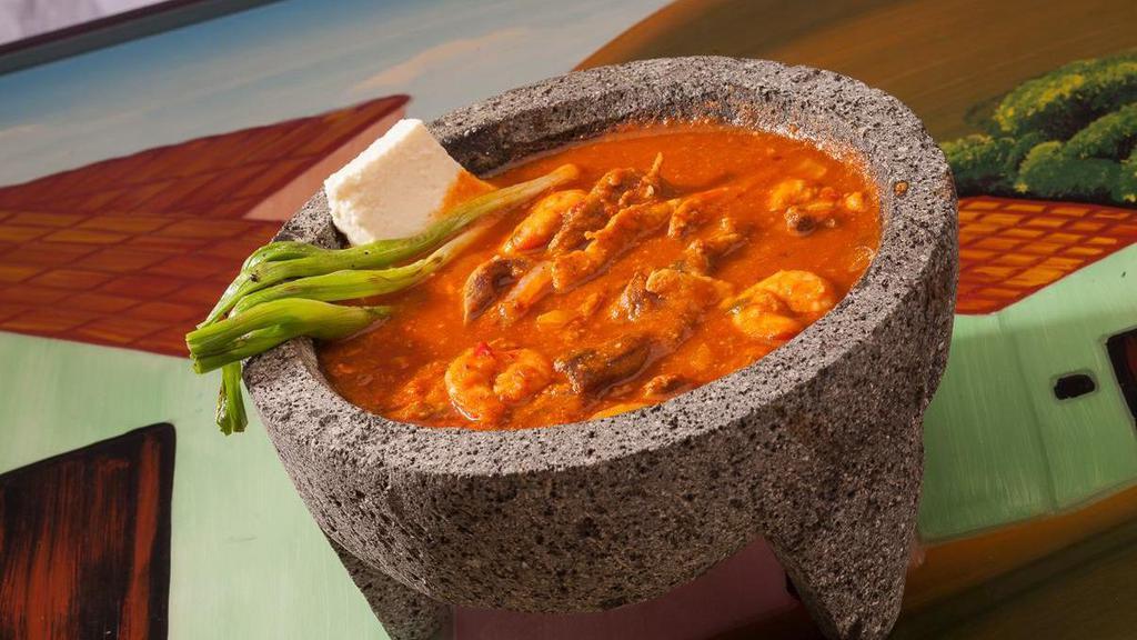 Molcajete · Spicy. Grilled steak, chicken, chorizo and shrimp sautéed in a special hot sauce, garnished with queso fresco and green onions. Served in a lava rock bowl. Includes 2 sides and tortillas.
