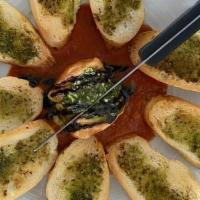 Baked Goat Cheese · Goat cheese coated with crouton crumbs served with french bread basted with pastachio- basil...