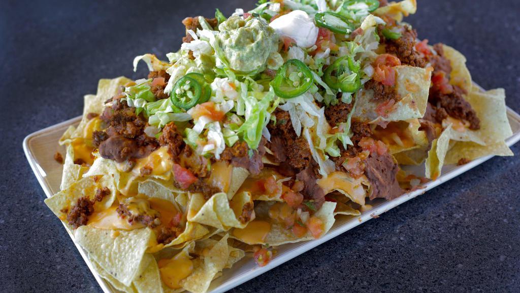 Tex Mex Nachos · Traditional nachos topped with your choice of seasoned beef or chicken. Refried beans, chile con queso, jalapenos, lettuce, pico de gallo, and sour cream sauce.