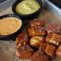 Pretzel Bites · Salted pretzel bites served with our chile con queso and spicy mustard.