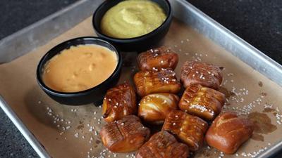 Pretzel Bites · Salted pretzel bites served with our chile con queso and spicy mustard.