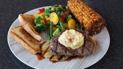 Mango-Pineapple Sirloin Steak* · A 6 oz. sirloin atop a bed of grilled pineapple and our mango-chile glaze, then topped with bacon butter. Served with two sides.