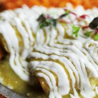 Enchiladas Suizas  · Corn tortilla filled with grilled chicken / green tomatillo sauce /. sour cream / salad /. r...