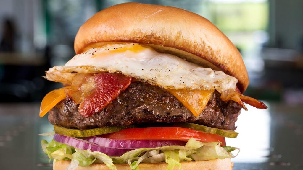 Hangover Burger · Topped with cheddar, smoky bacon, and a freshly fried egg, served atop shredded lettuce, tomato, red onion, and dill pickle chips. Served with fries.