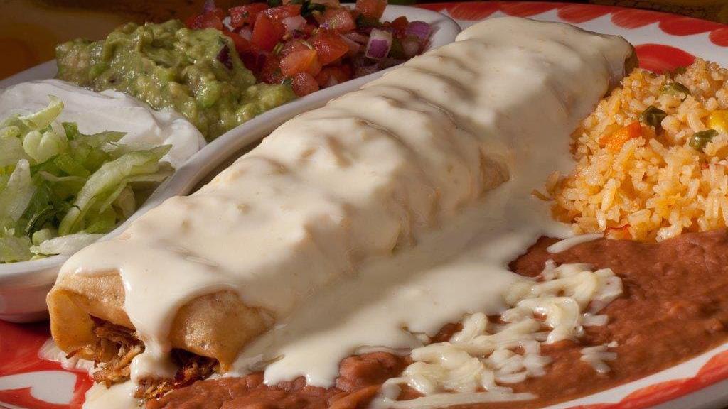 Chimichanga · A flour tortilla filled with your choice of chunks of beef or shredded chicken, deep-fried until golden brown and topped with cheese sauce. Served with lettuce, pico de gallo, guacamole and sour cream. Served with two sides.