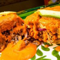 Torta Ahogada · Mexican specialty sandwich filled with carnitas, beans, onions, avocado, and smothered in sa...