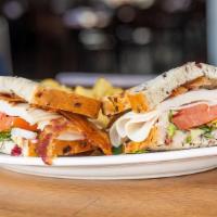 Turkey Club · Cranberry wild rice sourdough, bacon, lettuce, tomato, cranberry aioli, served with chips.