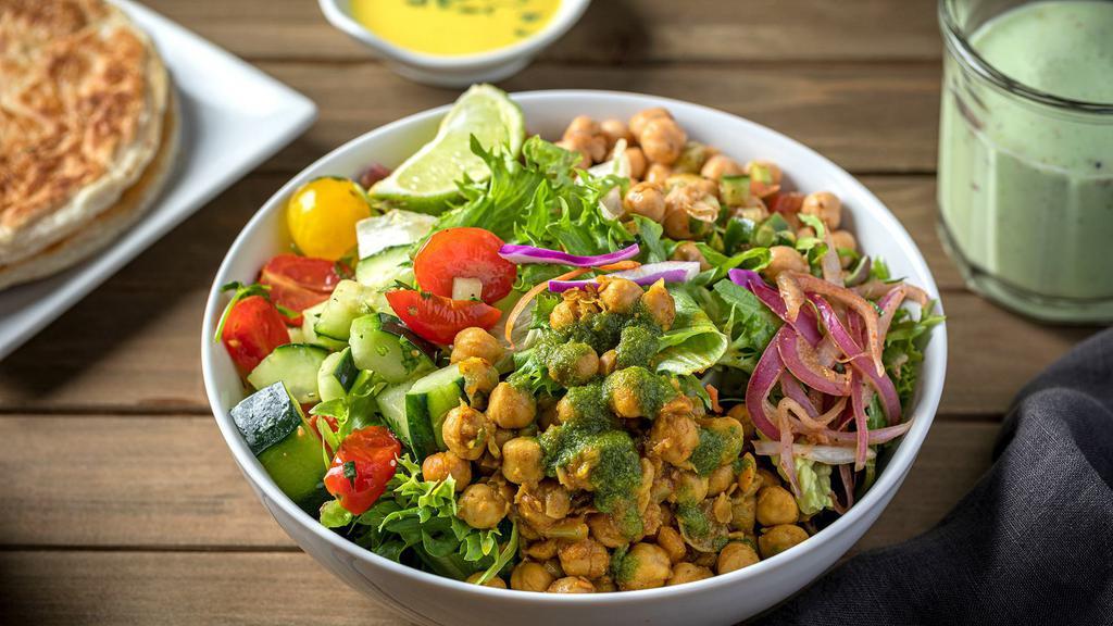 Chickpea Chana · Chickpeas simmered in an Indian spice blend, served over a bed of fresh cut salad (romaine & spring mix, chickpea mix, and cherry tomatoes & cucumber mix, finished with cilantro mint chutney & pickled onions + Side of ginger yogurt dressing. 
Gluten Free. Veg. Vegan.
