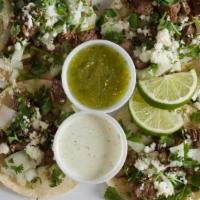 Street Tacos · Soft corn tortillas with onions, cilantro, lime, queso fresco with salsa verde and jalapeño ...