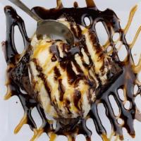 Brownie A La Mode (Sundae) · Warm brownie topped with vanilla bean ice cream and drizzled with chocolate and caramel sauce.