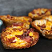 Potato Skins · Crispy potato boats filled with smoked bacon and melted Monterey Jack and cheddar cheeses.