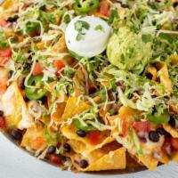 Knock-Out Nachos · Crisp tortilla chips with white Cheddar queso, melted Cheddar and Habanero Jack. Topped with...