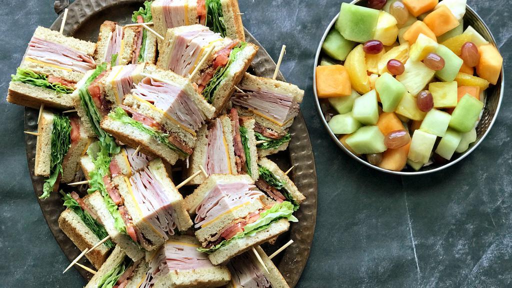 Party Platter Stacked-To-The-Max Club · (24 sandwich quarters) Sliced ham & turkey, crisp smoked bacon, Swiss & cheddar with lettuce, tomato & mayo. All stacked between three slices of toasted whole grain bread. Served with fruit salad.