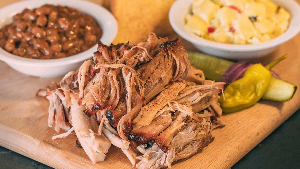 Pulled Pork Dinner · Includes our slow-smoked pulled pork, 2 of our delicious sides, pickle, pepper, onion & our famous BBQ sauce.