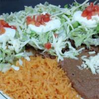 Tostadas Dinner · Three open face tacos topped with beans, lettuce, tomatoes, cheese, sour cream, with your ch...