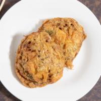Pork Egg Foo Young · An omelet filled with pork, bean sprouts and green onion served with gravy.