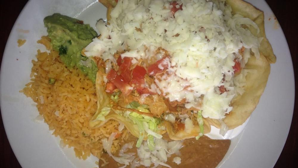 Taco Salad · Crispy flour shell filled with ground beef or chicken, lettuce, cheese, and tomato with a side of sour cream. Served with rice and beans.