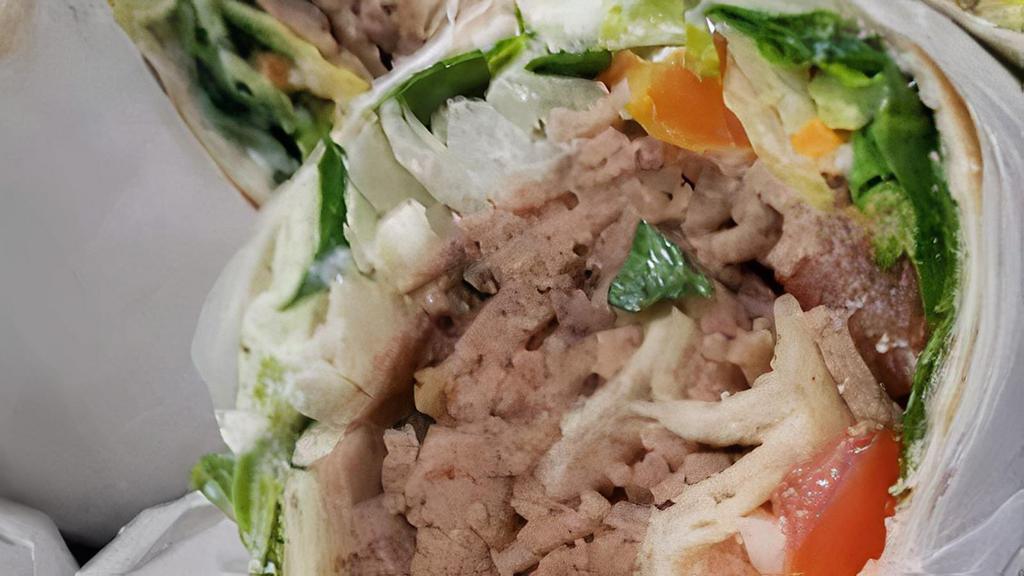 Lamb Gyro · Marinated lamb pieces, seasoned to perfection, served in a pita with lettuce, tomatoes, and our special dressing.