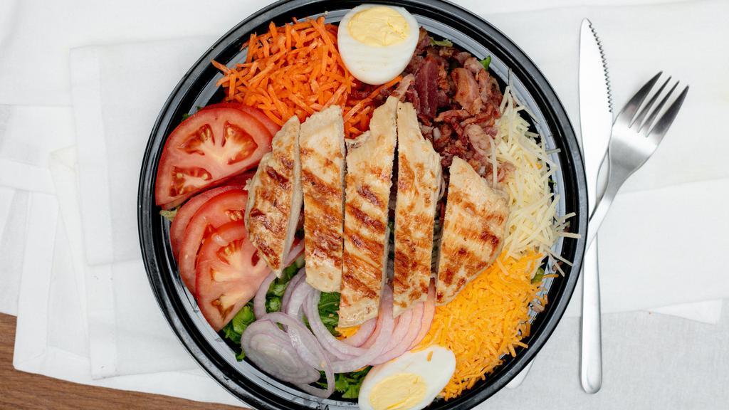 Chicken Chopped Salad · Iceberg lettuce, grilled chicken breast, diced tomatoes, diced cucumbers, diced onion, shredded carrots, bacon, shredded cheese, croutons, and hard boiled egg.