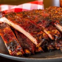 Slab Ribs · A full slab of our honey rubbed pork spare ribs slow smoked over hickory wood and cut to ord...