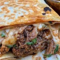 Burrito · Grilled 12 inch tortilla stuffed with Birria, flavorful rice, refried beans, extra cheese, o...