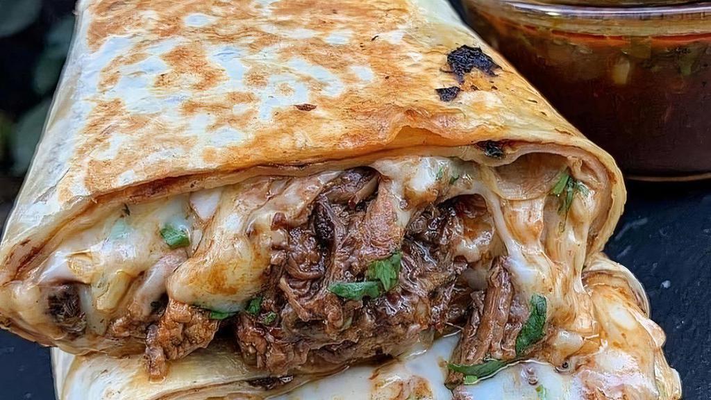 Burrito · Grilled 12 inch tortilla stuffed with Birria, flavorful rice, refried beans, extra cheese, onions and cilantro. Consome on the side for dipping!
