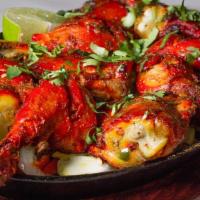 Tandoori Chicken · Spring chicken marinated in yogurt and spices and baked in our tandoori oven with sautéed on...