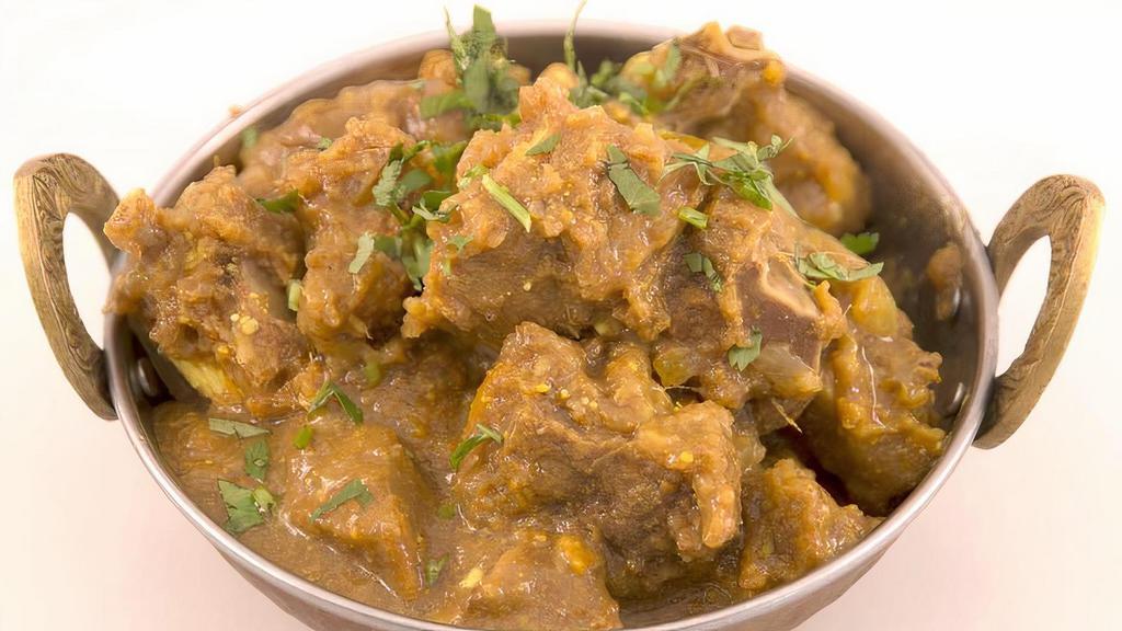 Goat Curry (With Bone) · Cubed goat (with bone) cooked in onions, tomato, garlic, and ginger and deliciously flavored Indian spices.