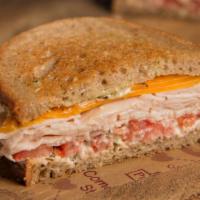 Lighthouse Turkey Cheddar Sandwich · Michigan turkey, cheddar and tomato with pesto mayo on whole wheat bread. Served with a pick...