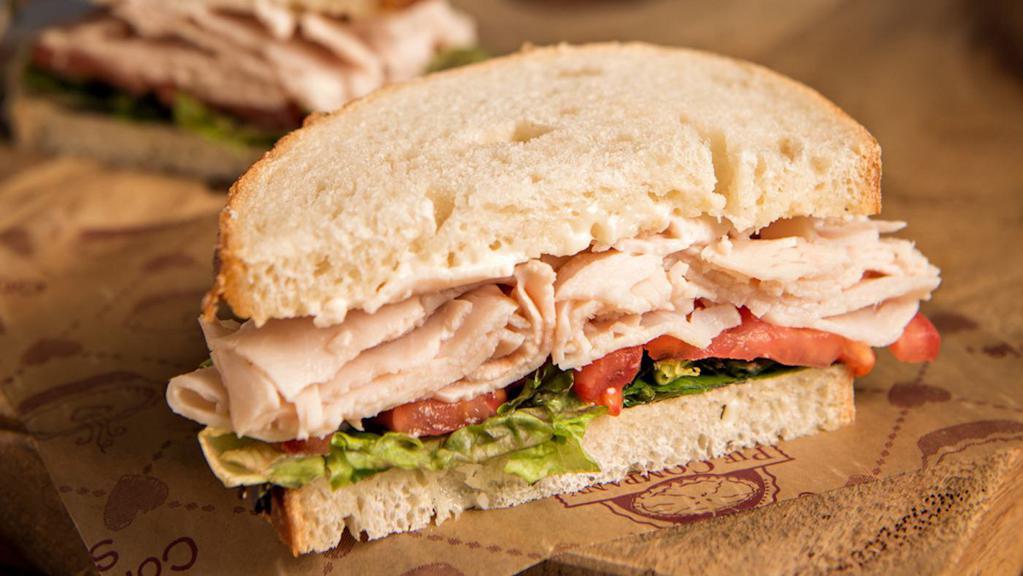 Classic Turkey Sandwich · Michigan turkey, tomato and lettuce with mayo on sourdough bread. Served with a pickle and choice of side.