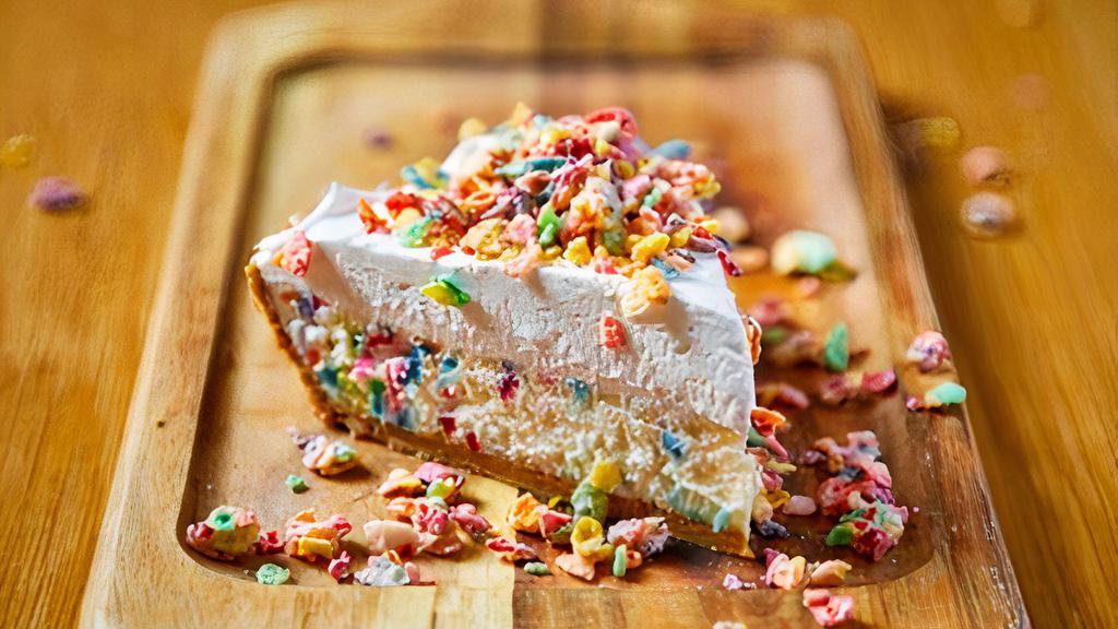 Fruity Pebbles Cheesecake · Funfetti cheesecake in a graham cracker crust topped with whipped cream and glazed fruitty pebbles.