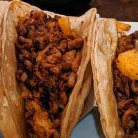Tacos Al Pastor · Pork tenderloin marinated in smoky guajillo sauce grilled with pineapple. Topped with onions...