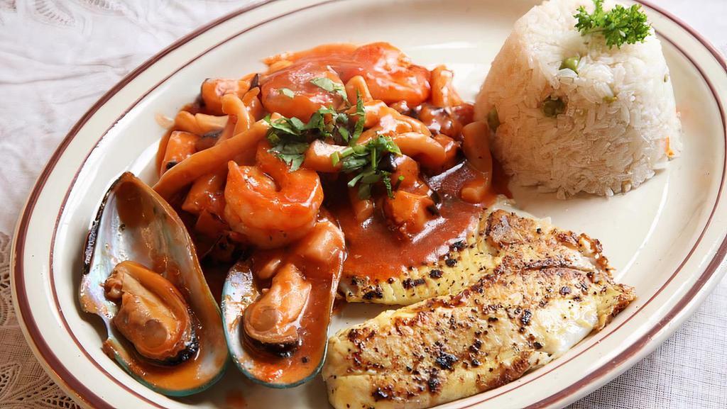 Pescado A Lo Macho · Grilled fish fillet with shrimps, octopus, squid, mussels, topped with a red creamy sauce, served with white rice.