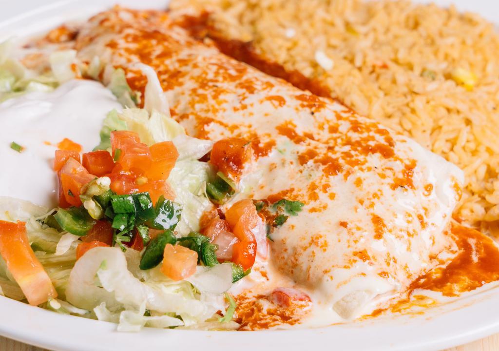 Texas Burrito · Burrito filled with grilled chicken, tomatoes and onions topped with ranchero and cheese sauce, served with Mexican rice jettuce sour cream and pico de gallo.
