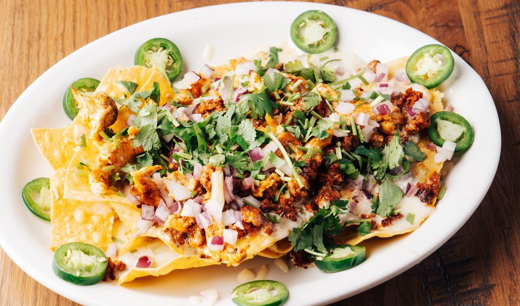 Nachos Del Rey · Nachos with grilled chicken strips, chorizo and salsa Verde, topped with cilantro, onions and fresh jalapeños.