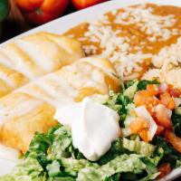 Chimichangas Supreme · Two chimichangas filled with choice of beef tips or chicken, covered with cheese sauce, serv...