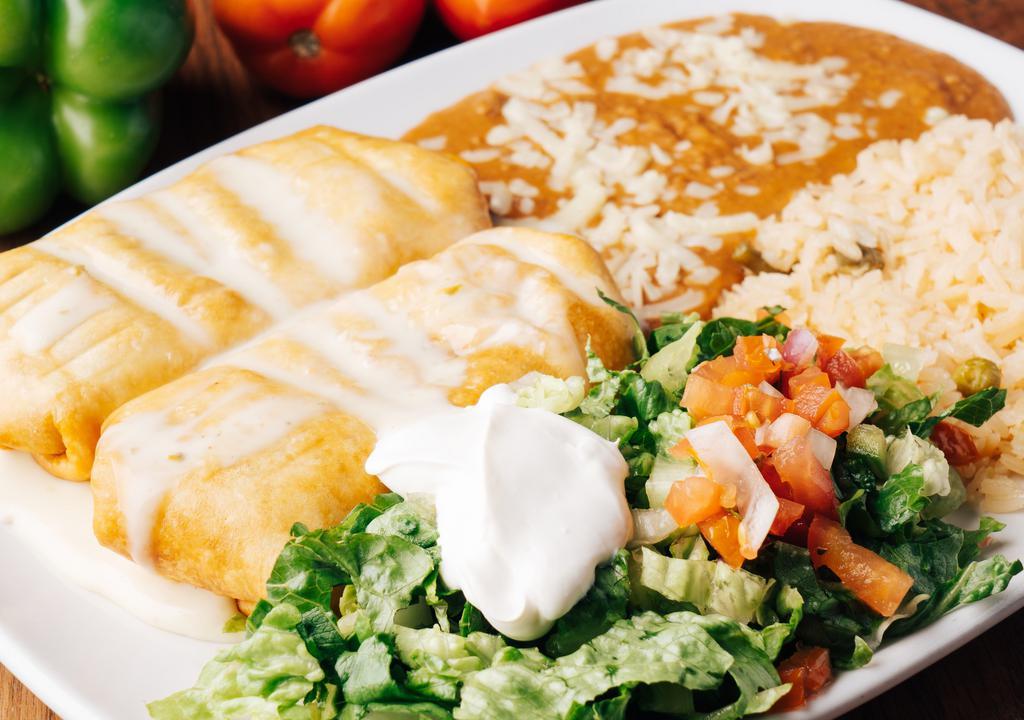 Chimichangas Supreme · Two chimichangas filled with choice of beef tips or chicken, covered with cheese sauce, served with Mexican rice, refried beans, lettuce, sour cream and pico de gallo.