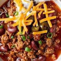 Chili · A house-made spicy blend of fresh beef, beans, onions and spices. Topped with Cheddar cheese...
