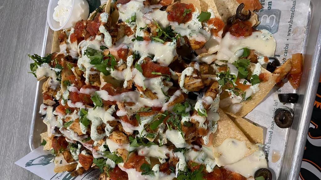 Loaded Nachos Or Totchos · Fresh fried corn chips or tots, queso, onions, jalapeños, tomatoes, olives, sour cream, and salsa.