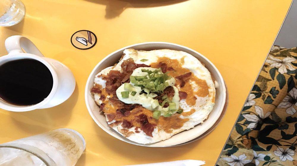 Breakfast Nachos · Crispy golden tater tots, covered with our cheese sauce, crispy bacon, house salsa and avocado crema with choice of eggs.